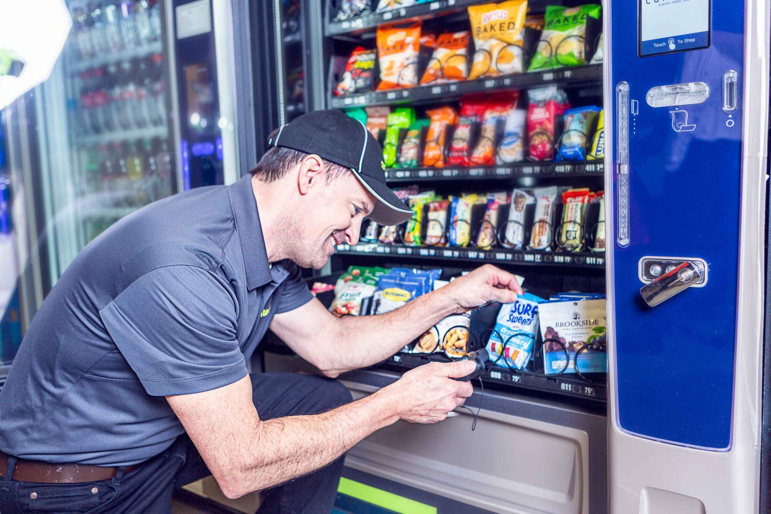 Customer using a modern vending machine stocked with snacks and drinks